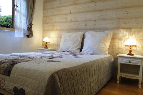 Foncine-le-HautGîte 1804 Montagnes du Jura avec Spa et Sauna classé 3 étoiles的一间卧室配有一张带2个床头柜的大床