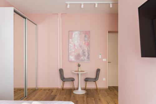 斯普利特Center De Lux Studios “ Zara “的配有桌子和两把椅子以及绘画的房间