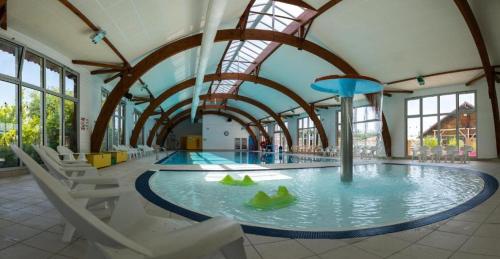 加斯泰"Mar e sou" 412 Camping La Réserve SIBLU的一个带椅子的健身房和一个室内游泳池