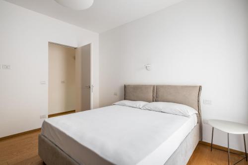 博洛尼亚Santo Stefano Design Apartment by Wonderful Italy的白色卧室内的一张白色床,配有桌子
