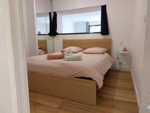 罗德兹Le DenysPuech 55m2 plein centre avec jardin!的一间卧室配有带粉红色枕头的床和窗户。