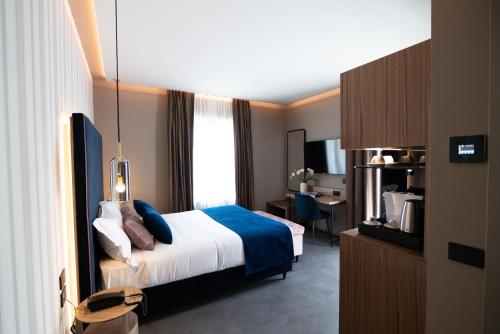 伊夫雷亚3T Boutique Hotel的配有一张床和一张书桌的酒店客房