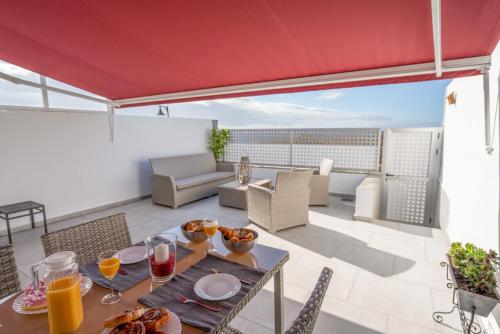 塔瓦伊瓦Luxurious apartment with large terrace and sea views的天井配有餐桌和食物
