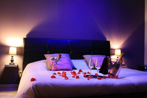 佩兹纳斯Le Loveappart的一间卧室,床上有红色玫瑰