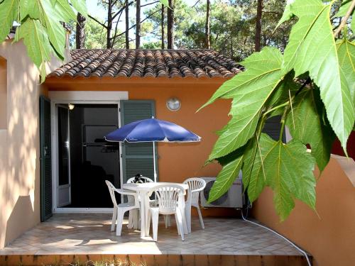 博尔戈Holiday Home Cala Bianca-1 by Interhome的庭院配有桌椅和遮阳伞。
