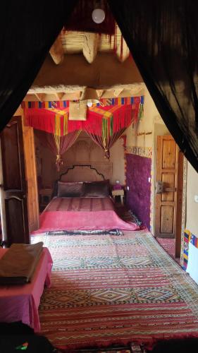 阿格兹Kasbah Maktob Tamnougalt的一间卧室配有一张带天蓬的大床