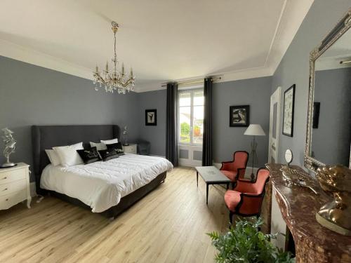 唐莱沃斯热La Maison Bleue « La Charade »的一间卧室配有一张床、镜子和椅子