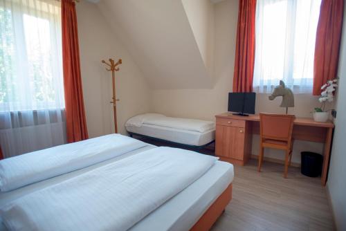 梅拉诺卡瓦利诺罗斯尔旅馆的一间卧室配有两张床和一张带电脑的书桌