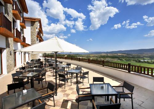 巴达古斯Hotel & Spa Real Badaguás Jaca的一个带桌椅和遮阳伞的庭院