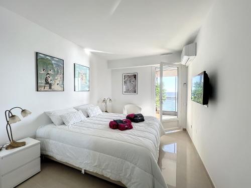 戛纳VILLA MAUPASSANT T2 BORD DE MER的白色卧室配有一张大床,上面装有两袋