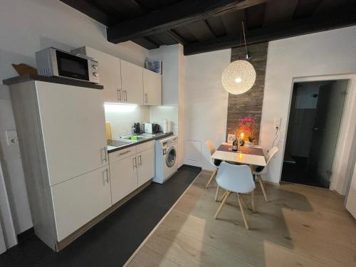 帕绍Apartment threeRivers的一间带桌子和微波炉的小厨房