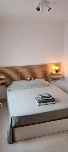 安波拉duplex appartement met zwembad, L'ampolla,的一间卧室配有一张大床和床头板