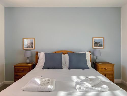 TangmereBright & Cosy - Jacuzzi - Log Burner - King Beds的一间卧室配有一张床,上面有两条毛巾