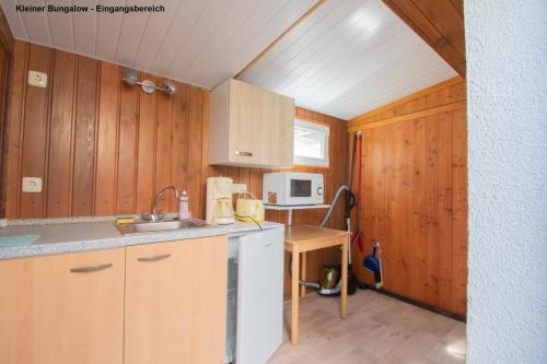 于克里茨Kleiner Bungalow - Zum Strand 50m的一个带木制橱柜和水槽的小厨房