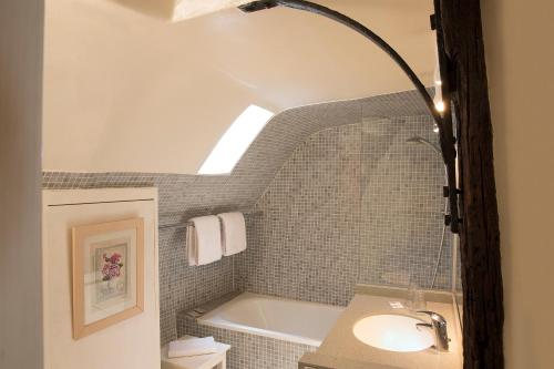 巴黎Hôtel du Cygne Paris的浴室配有盥洗盆和浴缸。
