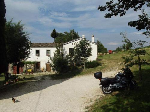 IelsiAgriturismo Masseria Testa Ciruglio的停在白色房子前面的摩托车