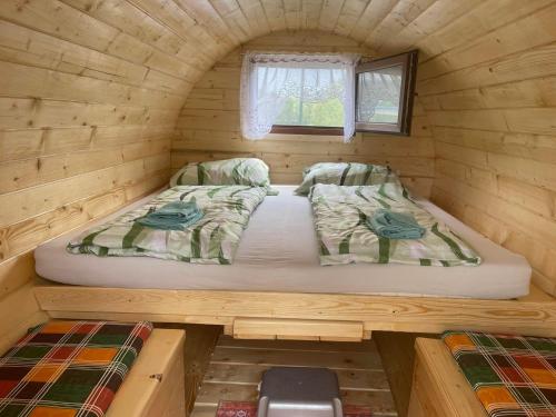 多瑙河畔埃默斯多夫Donaucamping Emmersdorf的配有窗户的小木屋内的一张床位