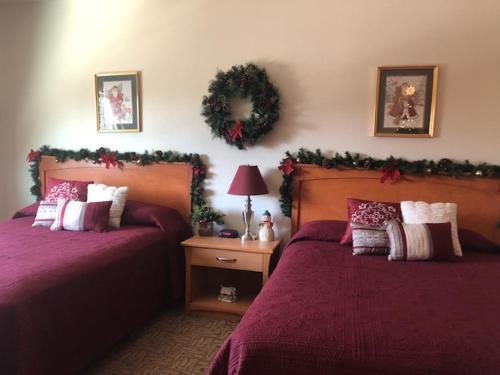 North Pole北极酒店的一间卧室设有两张床,墙上有花圈