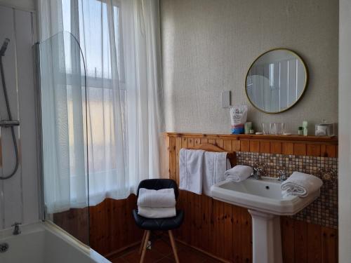 布莱克浦Sirocco Blues Guest House的一间带水槽、浴缸和镜子的浴室