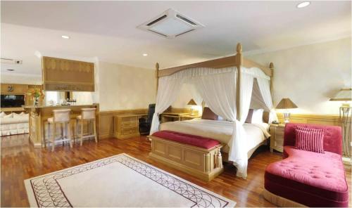 塞贝维塞贝维Spa度假酒店的一间卧室配有天蓬床和红色椅子