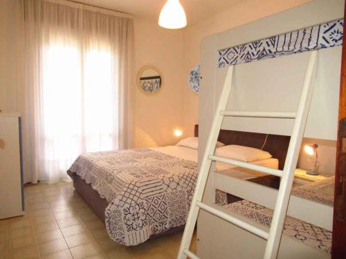 圣玛格丽塔波尔勒港Apartments in Porto Santa Margherita 42872的一间卧室配有带梯子的双层床