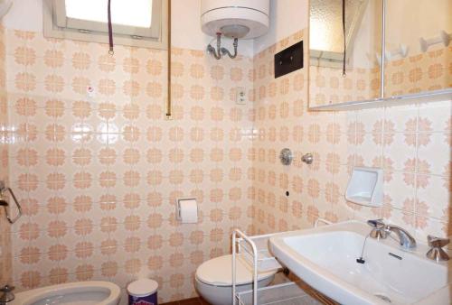 圣玛格丽塔波尔勒港Apartments in Porto Santa Margherita 42872的一间带水槽和卫生间的浴室