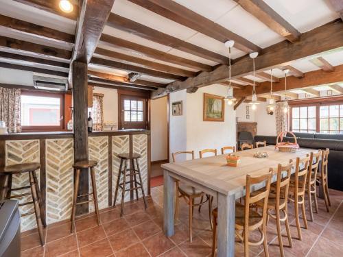 BeverenBeautiful Farmhouse in Beveren aan den IJzer with Terrace的厨房以及带木桌和椅子的用餐室。