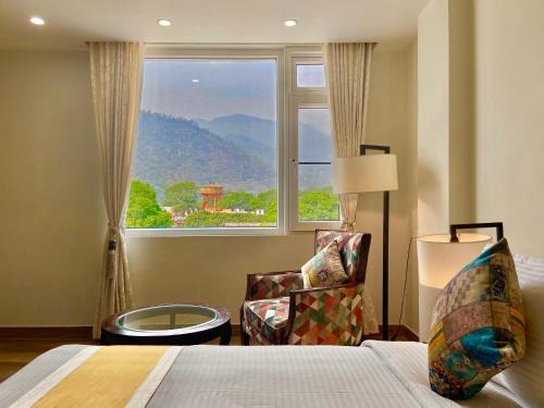 瑞诗凯诗Green View by Green Tree Hotels的一间卧室设有一张床、一个窗口和一把椅子