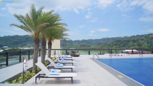 奥隆阿波Le Charmé Suites - Subic的游泳池旁的一排躺椅