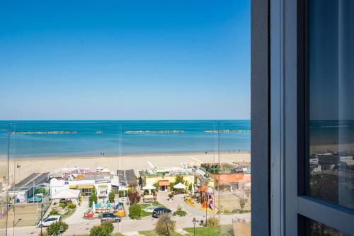 切塞纳蒂科Hotel Atlas的从大楼内可以欣赏到海滩和海洋的景致