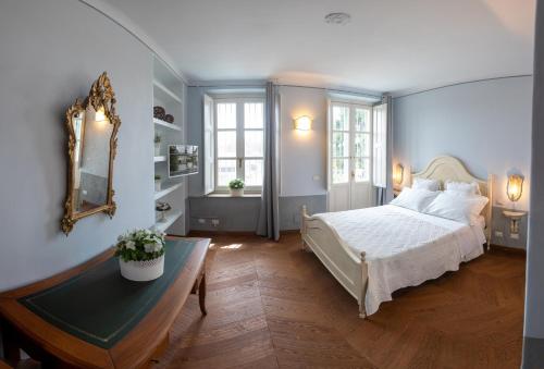 蒙卡列里B&B Villa Ricardi的一间卧室配有一张床、一张桌子和一面镜子