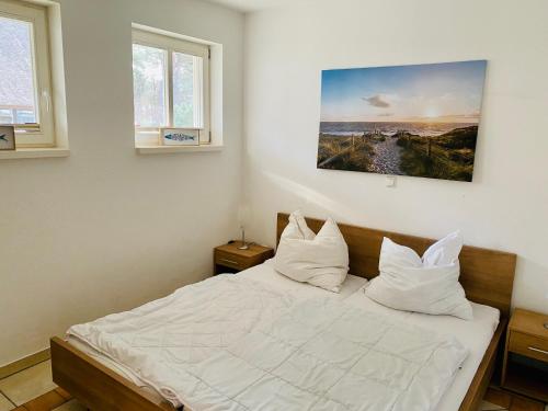 卡尔斯哈根100 Sekunden zum Strand: Schöne Wohnung auf Usedom的一间卧室配有带白色床单和枕头的床。