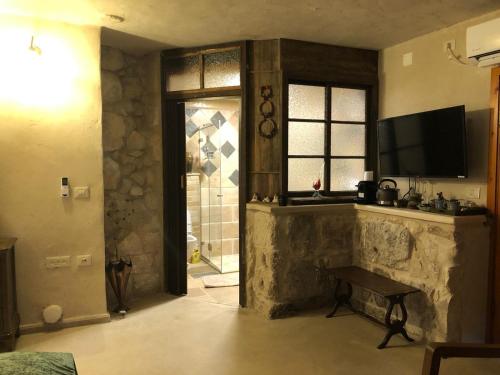 Mi‘ilyāChateau du Roi的一间带电视和石制壁炉的客厅