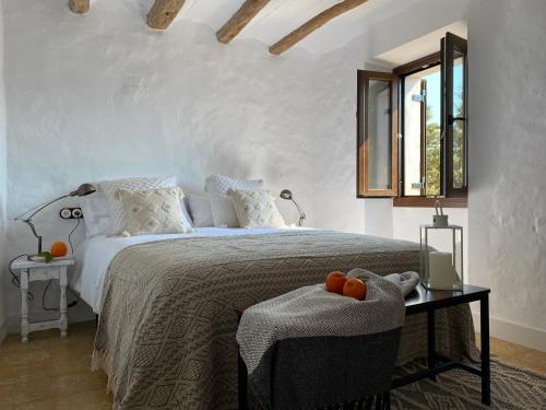 ArdenyaCasa rural con jardín,a 8km playa y en la naturaleza Taronja&canyella的一间卧室配有一张床和一张桌子,上面有橙子