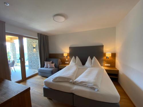 蓬高地区埃本Appartement Josef am Untersüßgut的配有一张床和一把椅子的酒店客房