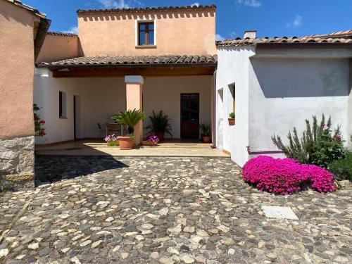 TuiliB&B Domenico Paulis的前面有粉红色花的房子