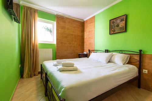 阿特米达Franceska's guest house的一间卧室设有一张带绿色墙壁的大床