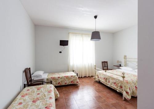 VenticanoAgriturismo Il Sentiero degli Ulivi - Irpinia的一间卧室设有两张床、一张桌子和一个窗口