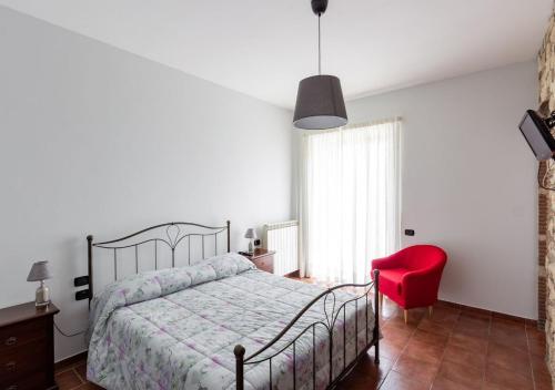 VenticanoAgriturismo Il Sentiero degli Ulivi - Irpinia的一间卧室配有一张床和一张红色椅子