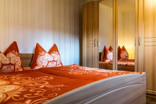 奔驰Holiday home in Benz/Insel Usedom 36664的一间卧室配有带橙色和白色枕头的床