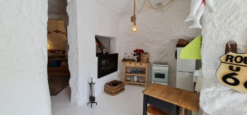 La CoruñaLos Andenes Cave的一间白色的小房间,配有桌子和厨房