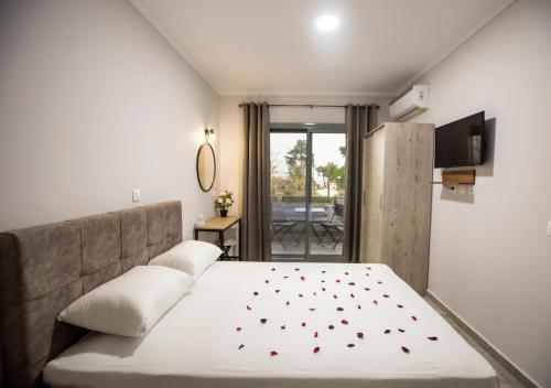 卡尼奥提Artemida Suites的一间卧室,配有一张红色的床