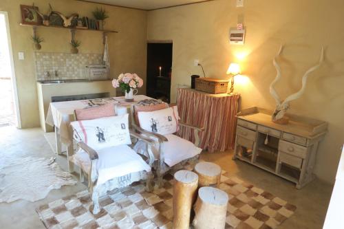 VosburgZeekoegat Country House BñB的配有桌椅和鲜花桌的房间