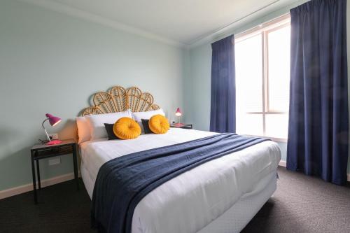 墨尔本Selina St Kilda Melbourne的一间卧室配有一张大床和两个黄色枕头