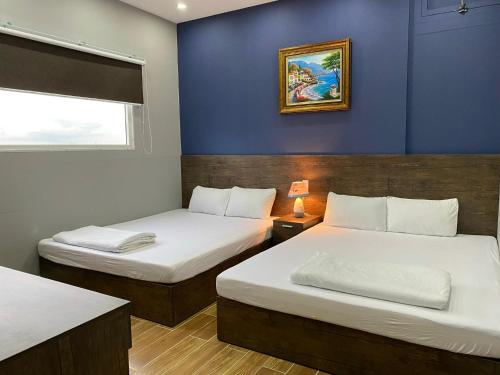 芹苴CONVOI HOTEL的一间卧室设有两张床和蓝色的墙壁