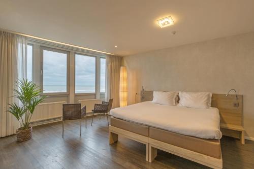 海滨诺德韦克Hotel de Baak Seaside的一间卧室设有一张床和一个大窗户