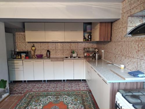 杜尚别3 floor quite cottage in Dushanbe的厨房配有白色橱柜和砖墙