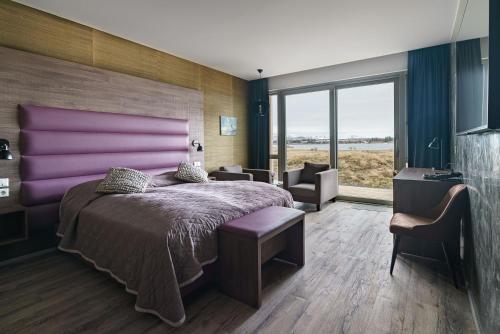 雷克雅未克Hotel Kriunes的一间卧室配有一张大床和紫色床头板