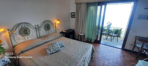 莱万托Hotel La Giada del Mesco的一间带大床的卧室和一个阳台