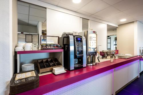 塞纳河畔罗米伊B&B HOTEL Romilly-sur-Seine的一间带苏打牌咖啡机的咖啡店
